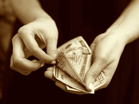 Honorar - Zahlungsweise (Symbolfoto) : Eine Fau zählt Dollarscheine ab. SJS Beratung, Praxis für Paartherapie